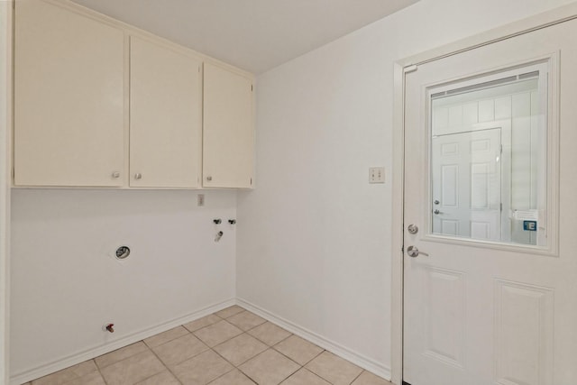 laundry room featuring cabinet space, light tile patterned floors, and baseboards