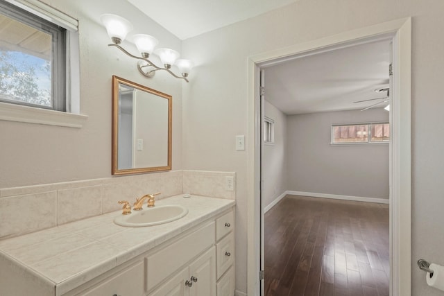 bathroom featuring a ceiling fan, vanity, baseboards, and wood finished floors