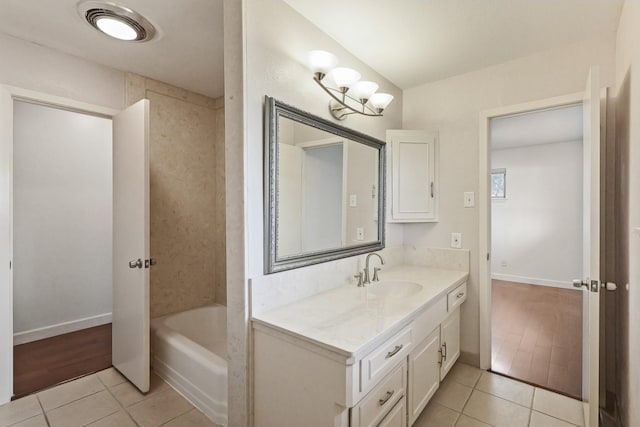 full bath with a bathtub, tile patterned flooring, vanity, and baseboards