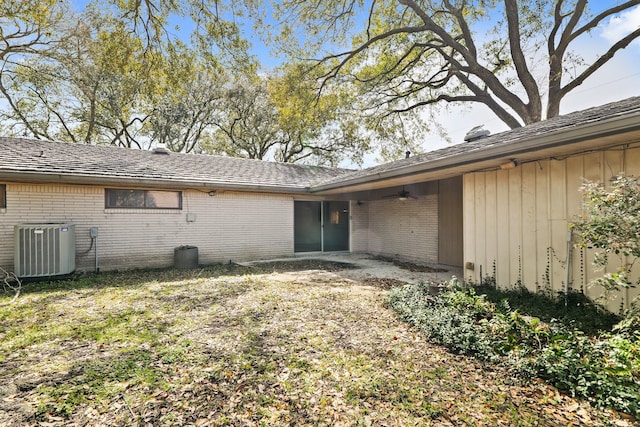 doorway to property with cooling unit, brick siding, and ceiling fan