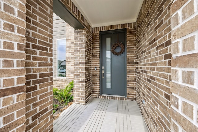 view of exterior entry featuring brick siding