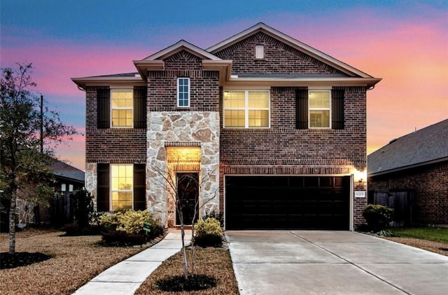 traditional-style home featuring an attached garage, driveway, brick siding, and stone siding