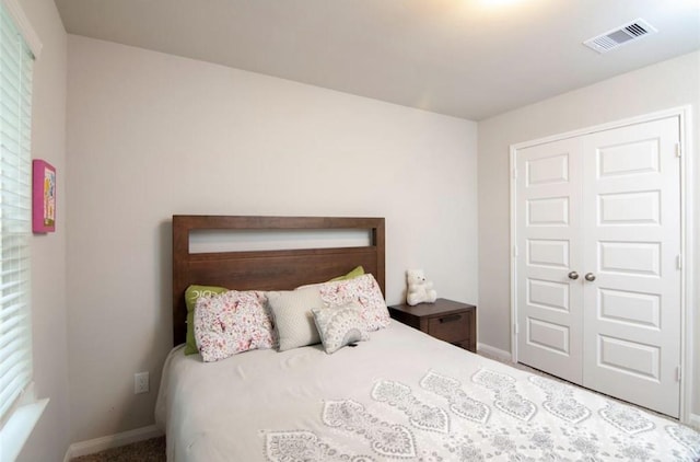 bedroom featuring carpet floors, visible vents, and baseboards