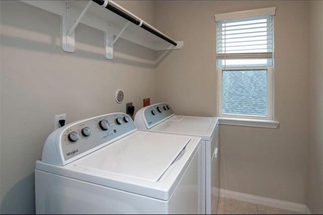 clothes washing area with laundry area, baseboards, and separate washer and dryer