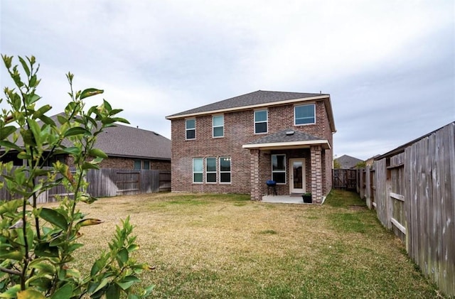 rear view of house with a patio area, a fenced backyard, brick siding, and a lawn