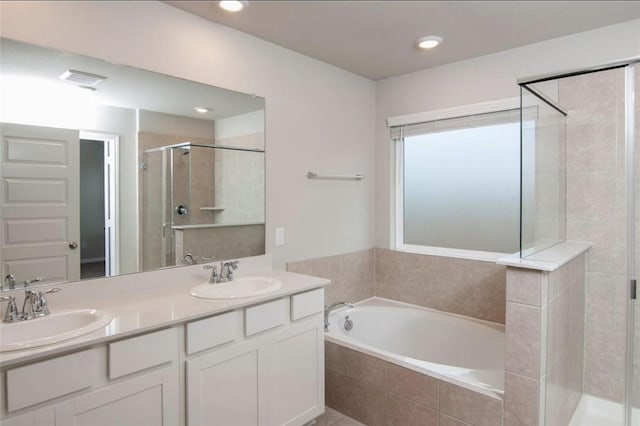 full bath with a garden tub, double vanity, a stall shower, and a sink