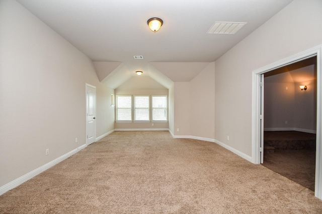 spare room featuring baseboards, visible vents, and light carpet