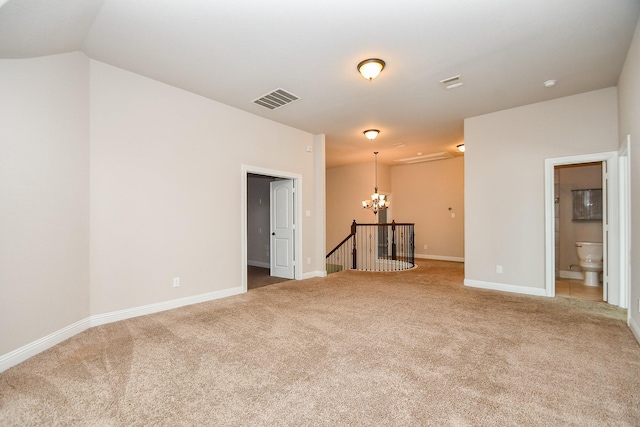 carpeted spare room with a chandelier, visible vents, baseboards, and vaulted ceiling