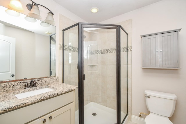 full bathroom with a shower stall, vanity, and toilet