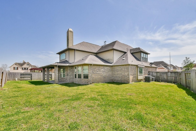 rear view of property with central air condition unit, a yard, and brick siding