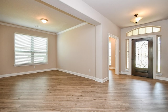 foyer featuring crown molding, visible vents, and light wood-type flooring