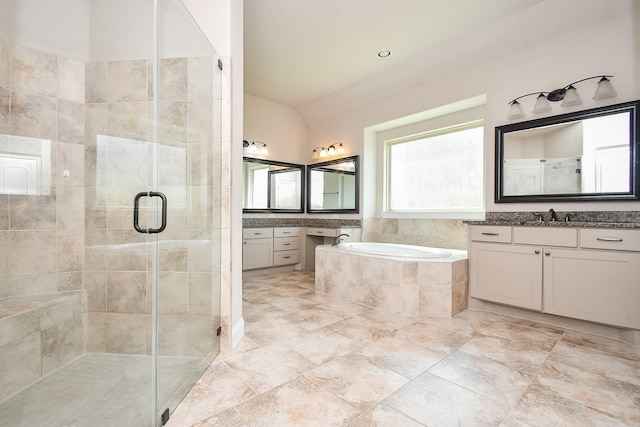 full bathroom featuring a sink, a shower stall, a garden tub, and two vanities