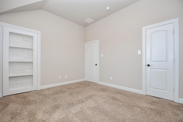 unfurnished bedroom featuring vaulted ceiling, baseboards, and carpet floors