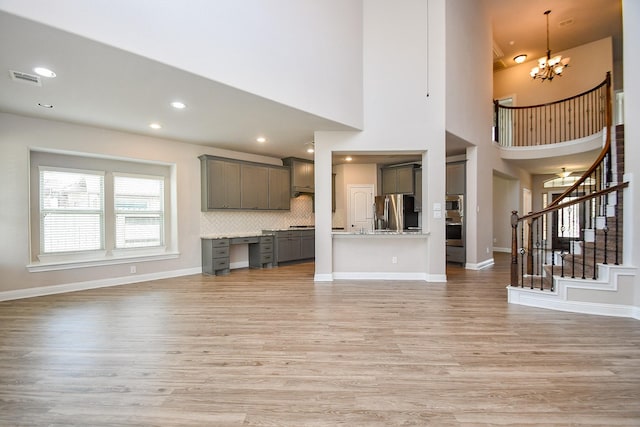 unfurnished living room featuring visible vents, recessed lighting, stairway, light wood-style floors, and baseboards