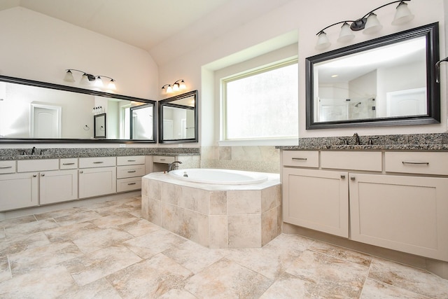 bathroom with lofted ceiling, a bath, a tile shower, and a sink