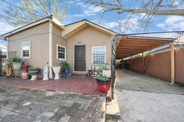 exterior space with driveway, an attached carport, and fence