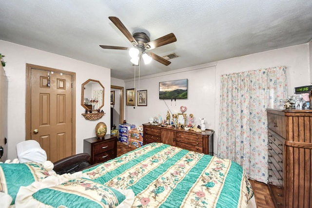 bedroom featuring ceiling fan, visible vents, and a textured ceiling