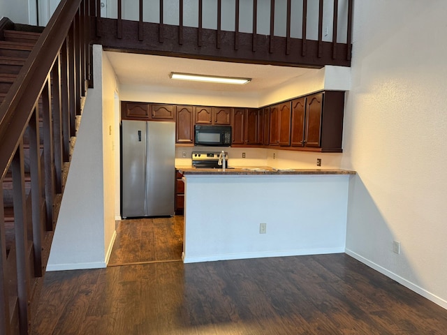 6341 Shadow Tree Dr, Houston, TX 77035 - kitchen with freestanding refrigerator, black microwave, dark wood finished floors, a peninsula, and range with electric cooktop