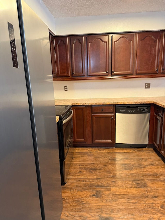 6341 Shadow Tree Dr, Houston, TX 77035 - kitchen featuring appliances with stainless steel finishes, dark wood-style flooring, dark brown cabinets, and light stone counters