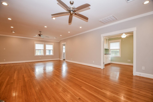 unfurnished room featuring crown molding, light wood-style flooring, baseboards, and visible vents