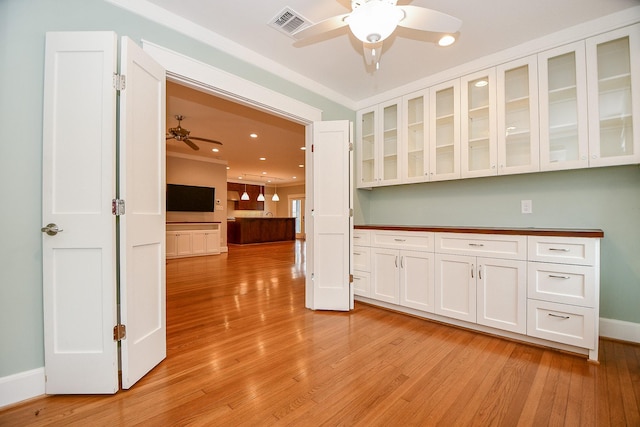 kitchen featuring light wood-style flooring, white cabinets, glass insert cabinets, and ceiling fan