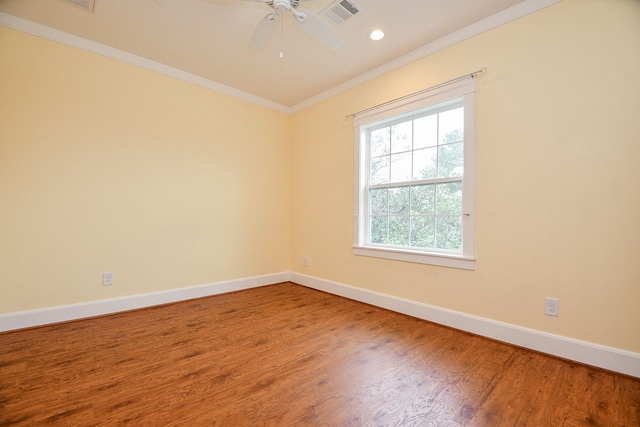 unfurnished room with baseboards, wood finished floors, visible vents, and ornamental molding