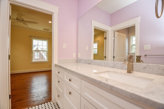 bathroom with visible vents, baseboards, a healthy amount of sunlight, and vanity