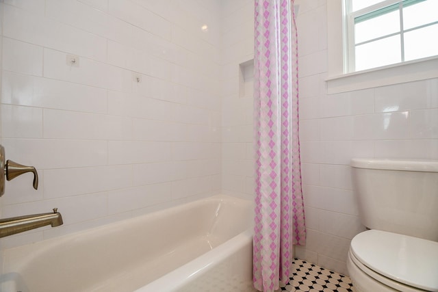 full bathroom with tile walls and toilet