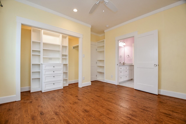 unfurnished bedroom with crown molding, wood finished floors, baseboards, and ensuite bathroom