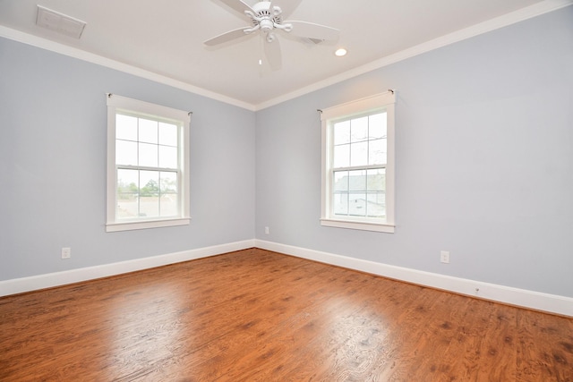 empty room featuring ornamental molding, ceiling fan, baseboards, and wood finished floors