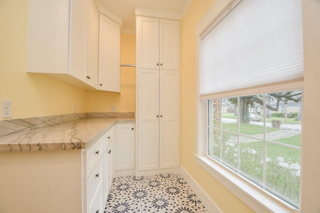 kitchen featuring white cabinets, light countertops, and baseboards