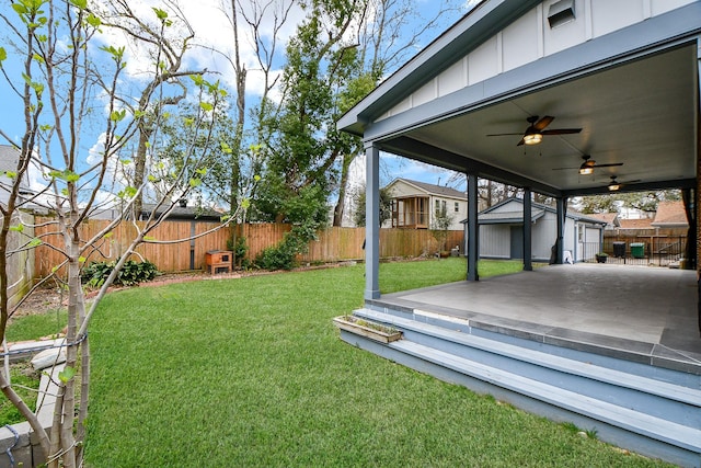 view of yard with an outbuilding, a fenced backyard, a patio area, and ceiling fan