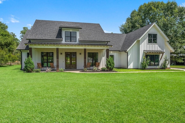 modern farmhouse style home with french doors, board and batten siding, a front yard, and a shingled roof