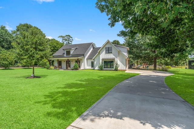 modern inspired farmhouse featuring board and batten siding, a front lawn, and roof with shingles