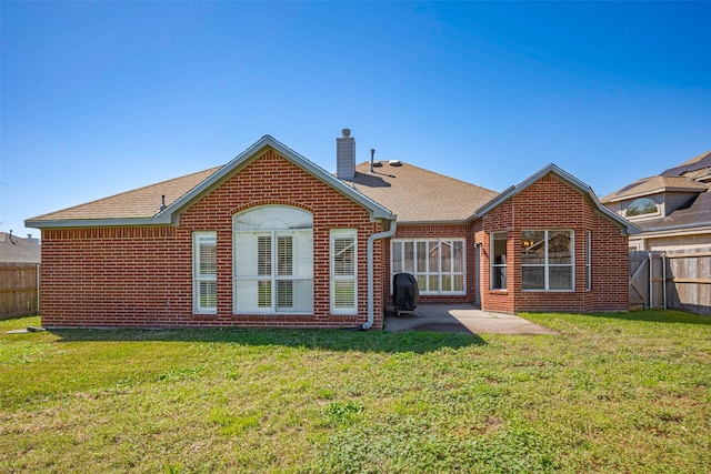 rear view of house featuring brick siding, a chimney, a patio area, and a fenced backyard