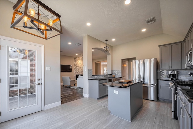 kitchen with visible vents, decorative backsplash, dark countertops, appliances with stainless steel finishes, and gray cabinetry