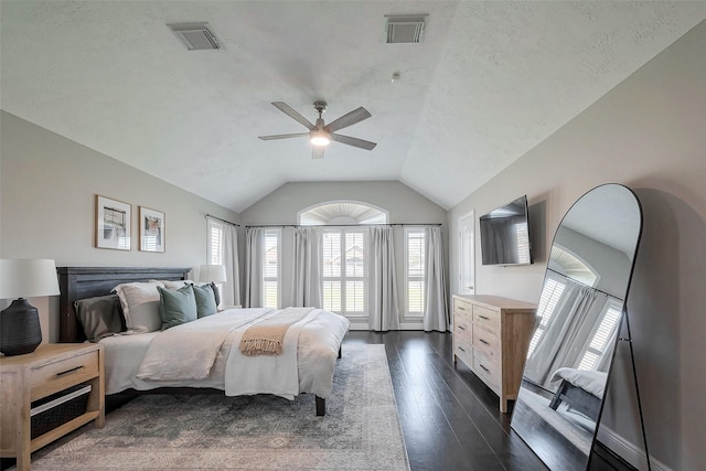 bedroom with dark wood-style floors, ceiling fan, visible vents, and vaulted ceiling