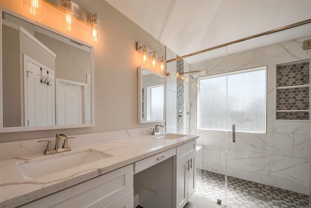 bathroom featuring double vanity, a marble finish shower, visible vents, and a sink