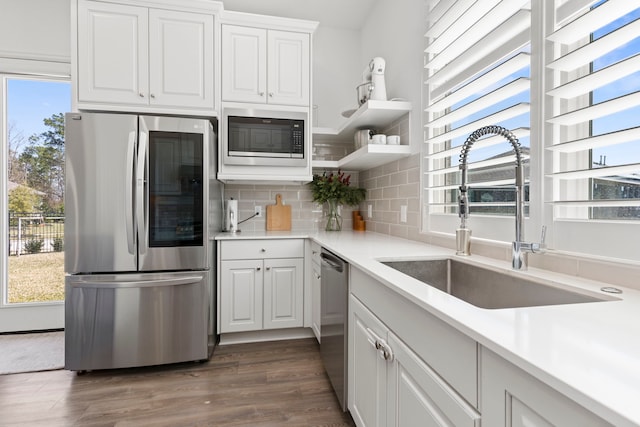 kitchen with a sink, a healthy amount of sunlight, tasteful backsplash, and stainless steel appliances