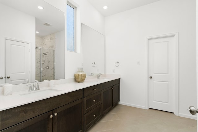 bathroom featuring a sink, a marble finish shower, baseboards, and double vanity