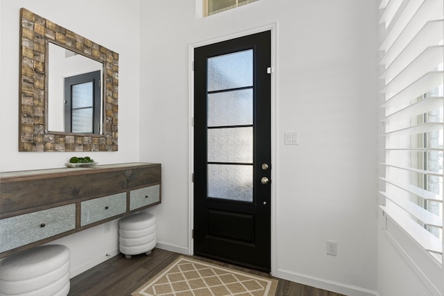 foyer entrance featuring baseboards and dark wood-style flooring