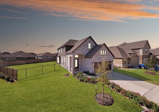 view of front of house featuring driveway, a front lawn, fence, a residential view, and brick siding