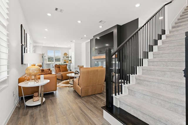 living room featuring stairway, recessed lighting, wood finished floors, and baseboards