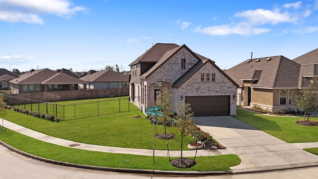 french country inspired facade featuring fence, concrete driveway, a front yard, a garage, and brick siding