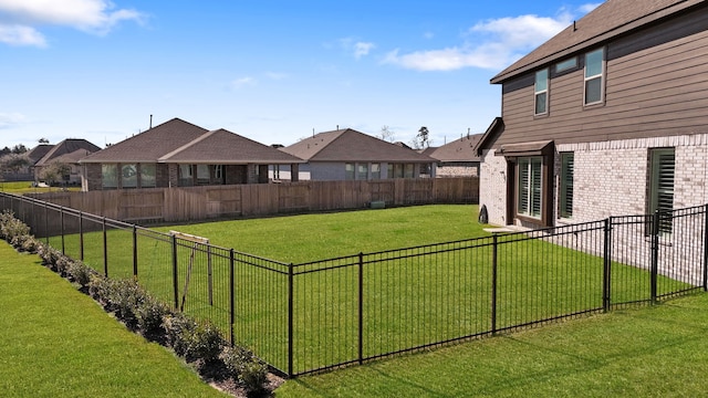 view of yard featuring a fenced backyard and a residential view