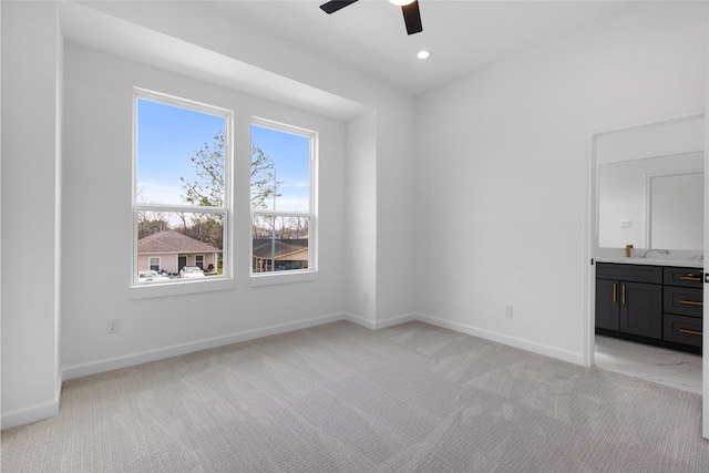 unfurnished bedroom with recessed lighting, light colored carpet, connected bathroom, and baseboards