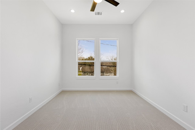 empty room with light carpet, visible vents, and baseboards