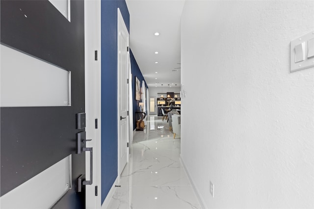 hall featuring marble finish floor, baseboards, and recessed lighting