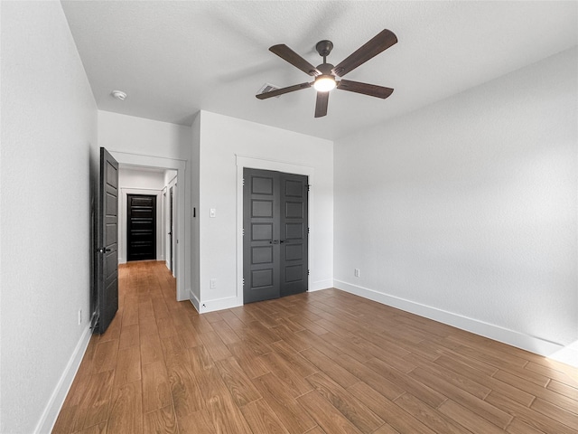 unfurnished bedroom featuring a ceiling fan, baseboards, and wood finished floors