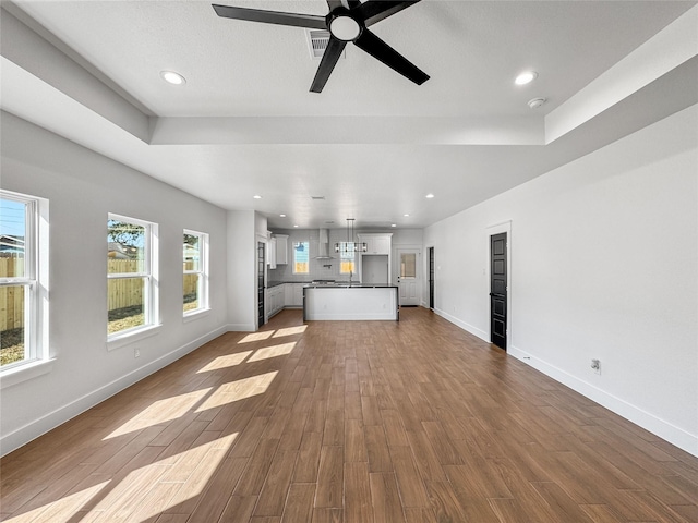 unfurnished living room featuring dark wood-type flooring, recessed lighting, visible vents, and baseboards